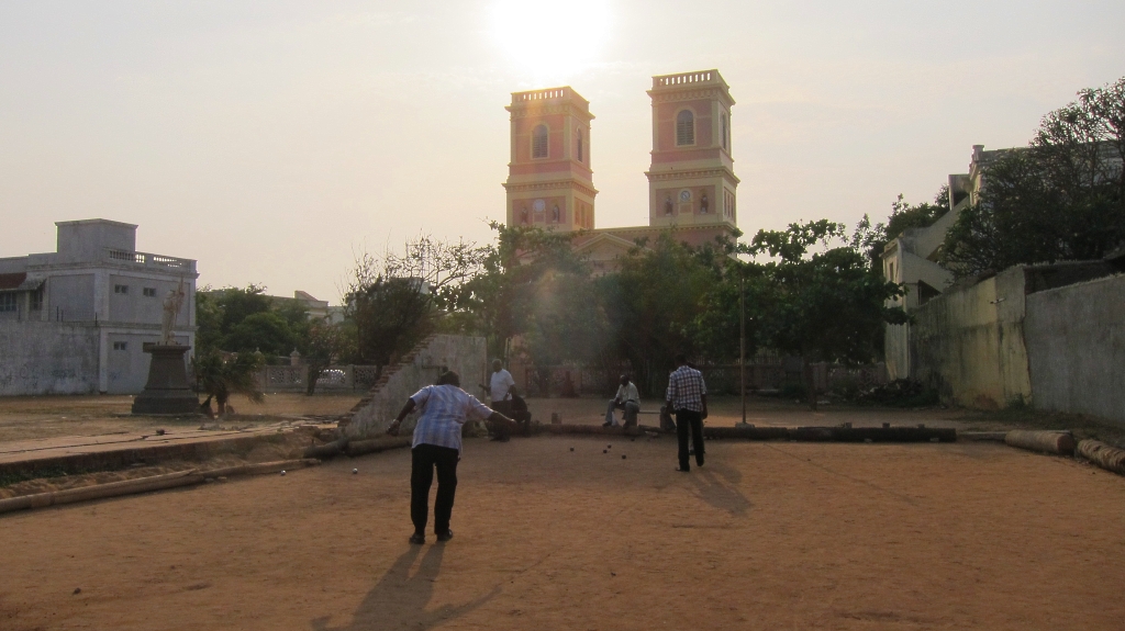 Des indiens jouant à la pétanque avec l'église façon Notre-Dame en arriere-plan: mythique.